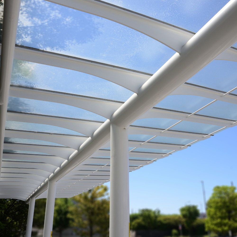 toiture en polycarbonate compact transparent sur structure métallique.